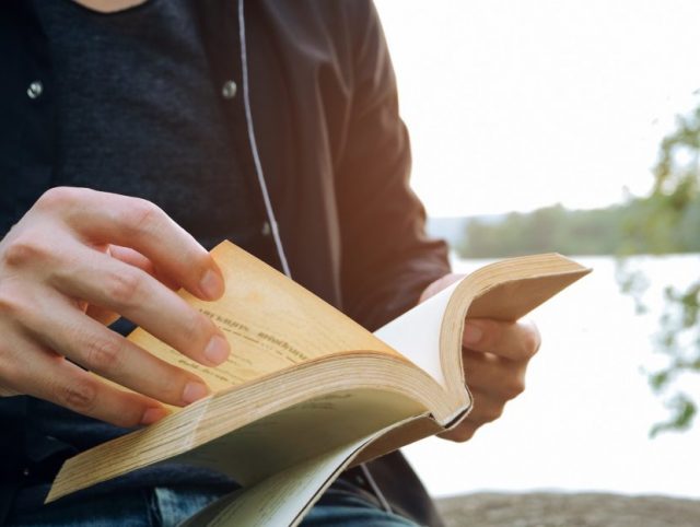 Relaxing moments, Young man opening and reading a book. Relax time on holiday concept travel, Thailand.